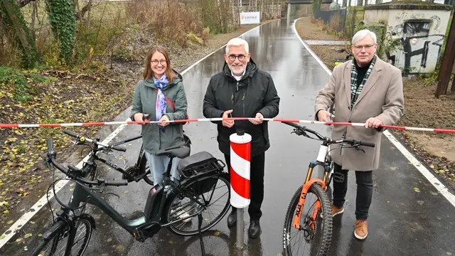 Ronja Reyes Henriquez, die Vorsitzende des Ausschusses für Sicherheit, Umwelt und Nachhaltigkeit, Oberbürgermeister Jörg Lukat und Dr. Peter Reinirkens, der Vorsitzende des Ausschusses für Mobilität, Digitalisierung und Infrastruktur durchtrennen symbolisch die Absperrung der neuen Opeltrasse | Foto: Stadt Bochum