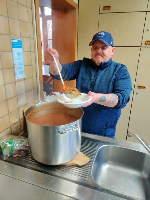 Das Foto zeigt Maik Züllinger, Hausmeister in der Evangelischen Kirchengemeinde Ruhrort-Beeck, beim Einschenken einer Suppenportion.
Foto: Ruhrort-beeck.de