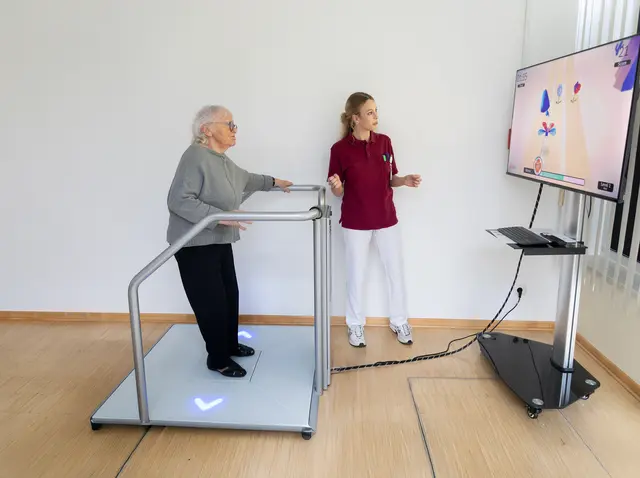 Karin Arnhold (82, Foto) hat sich bei einem Sturz den Oberschenkel gebrochen. Vier Wochen nach der notwendigen Operation steht sie auf dem "Thera Trainer" und absolviert Videospiele. Zum Beispiel schlüpft sie in die Rolle eines Marienkäfers, der Blumen einsammeln und Kakteen ausweichen muss. "Das ist ganz lustig", sagt sie, hat aber auch einen hohen medizinischen Wert. | Foto: KEM / Ines Walter