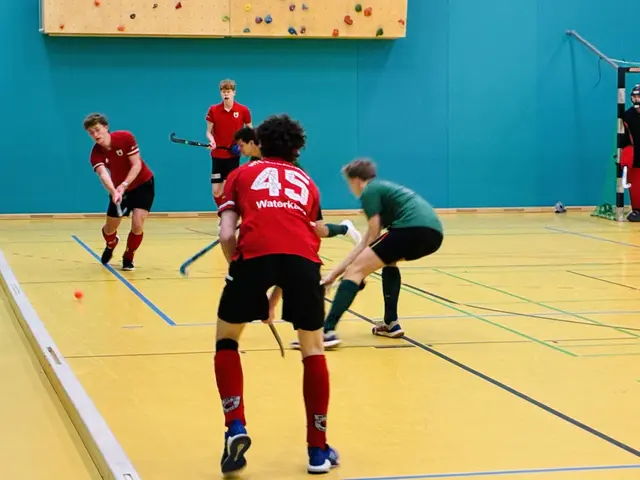 Gegen Raffelberg reichte es für den HTC Kupferdreh trotz eines Blitzstarts und einer frühen Führung nicht zum erhofften Sieg. In dieser Szene befördert Tom Schwabe, attackiert von zwei Raffelbergern, den Ball entlang der Bande aus der Gefahrenzone.  | Foto: Carsten Ackermann