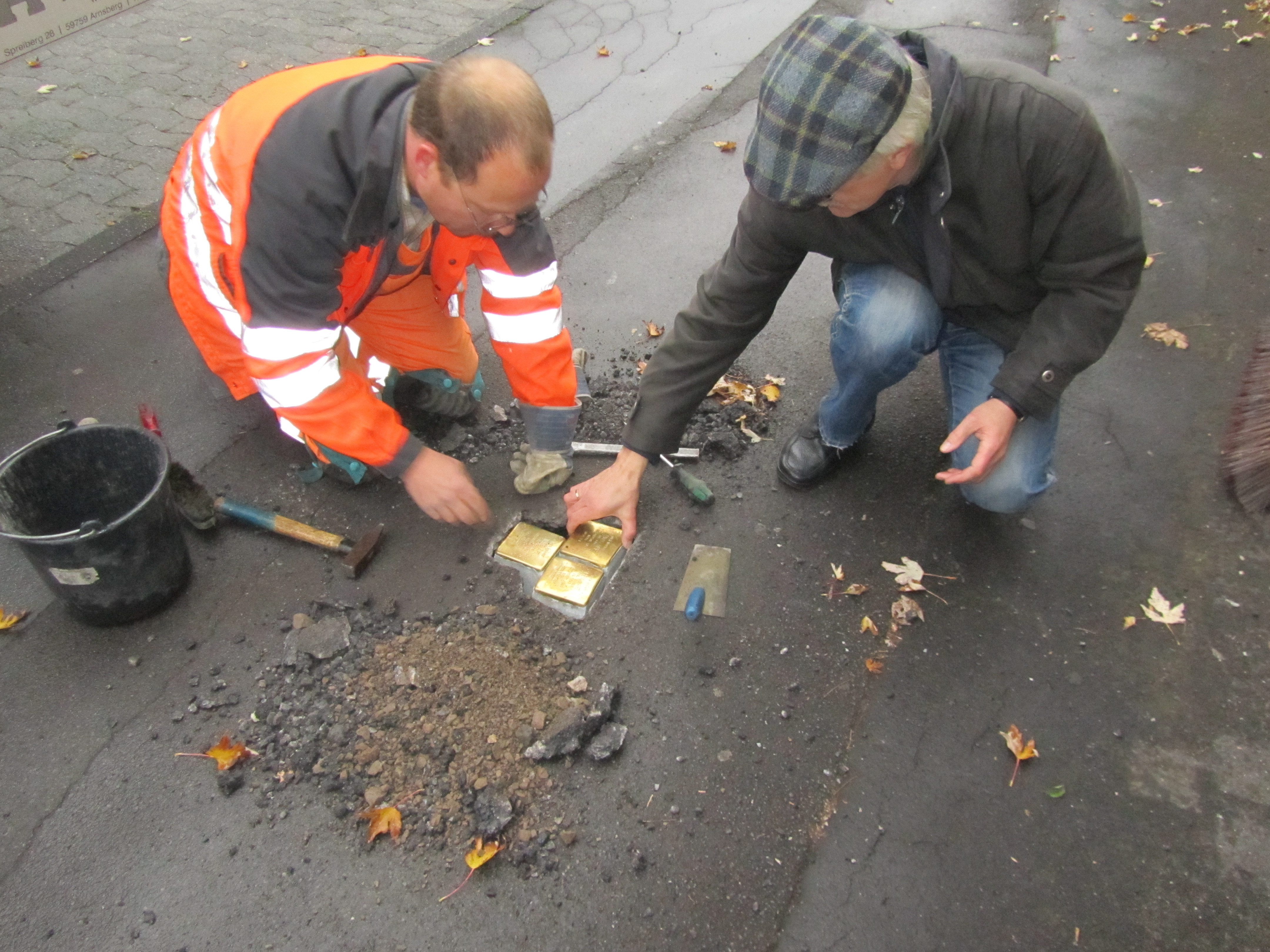 Stolpersteine: Im Auftrag des Künstlers werden die Steine eingepasst.