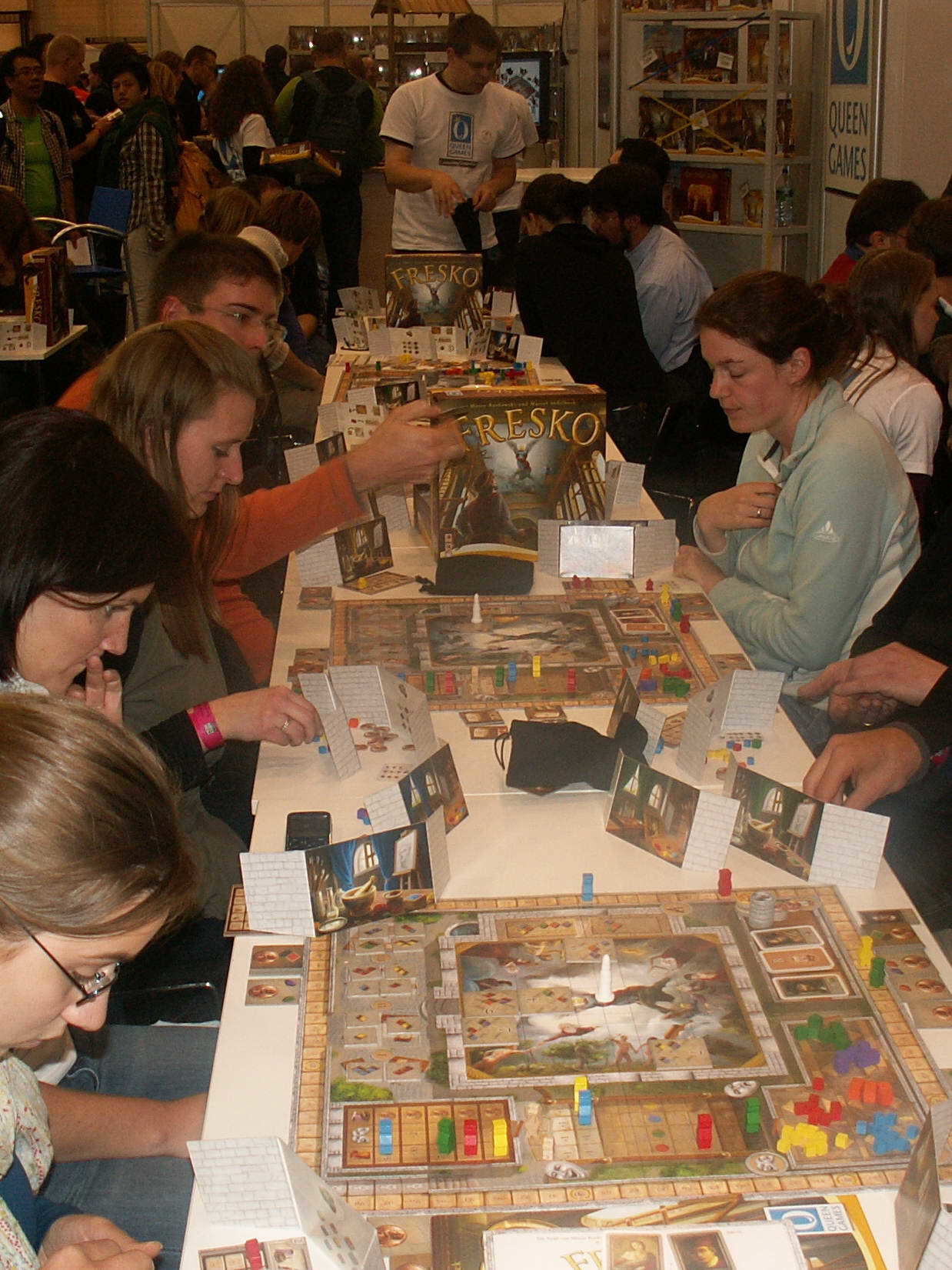 Stand von Queen-Games auf der Messe - viele Tische und alle spielen Fresko
