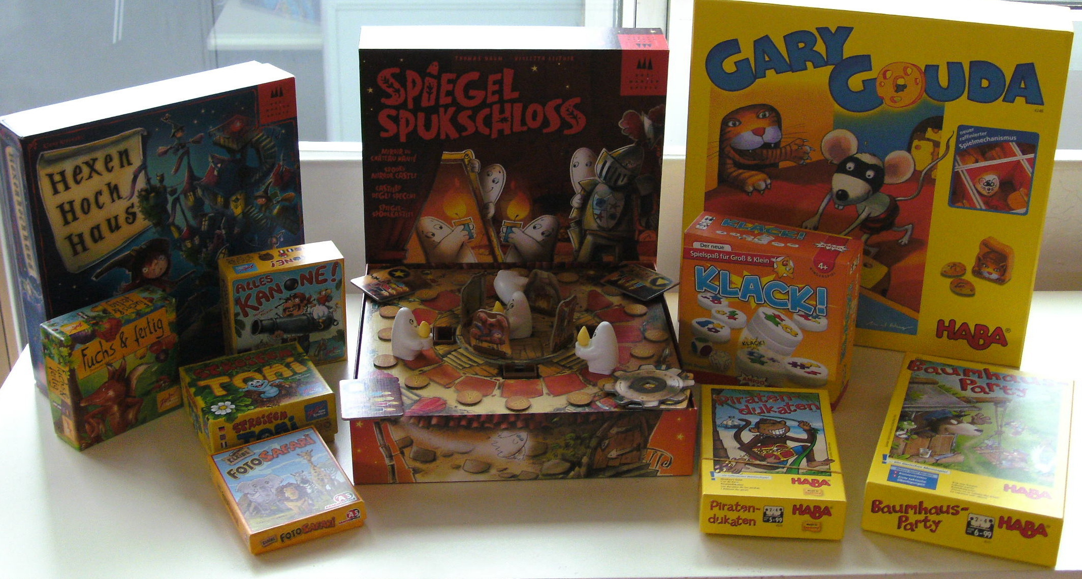Die mitgebrachten Kinderspiele. In der Mitte aufgebaut "Spiegel Spukschloss" von Drei Magier Spiele.