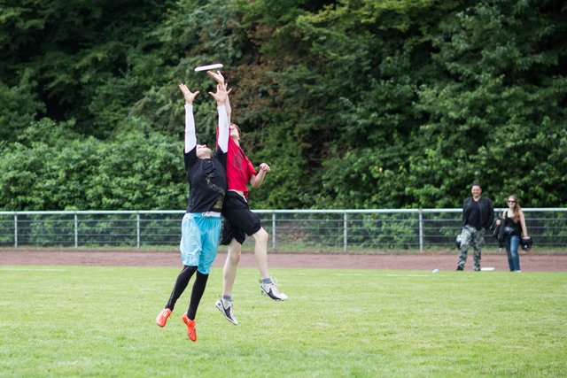 Ein Zweikampf um die Frisbee-Scheibe mit interessierten Zuschauern.