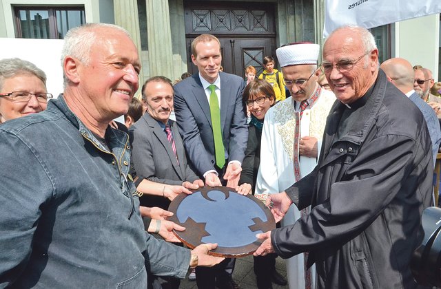 Zusammen mit den Vertretern der Religionen und der Stadt - wie dem damaligen Bürgermeister Dr. Jan Heinisch (Mitte) - setzte der Künstler Gregor Merten im April 2015 die Intarsie des „Engels der Kulturen“ in das Pflaster vor dem Rathaus.