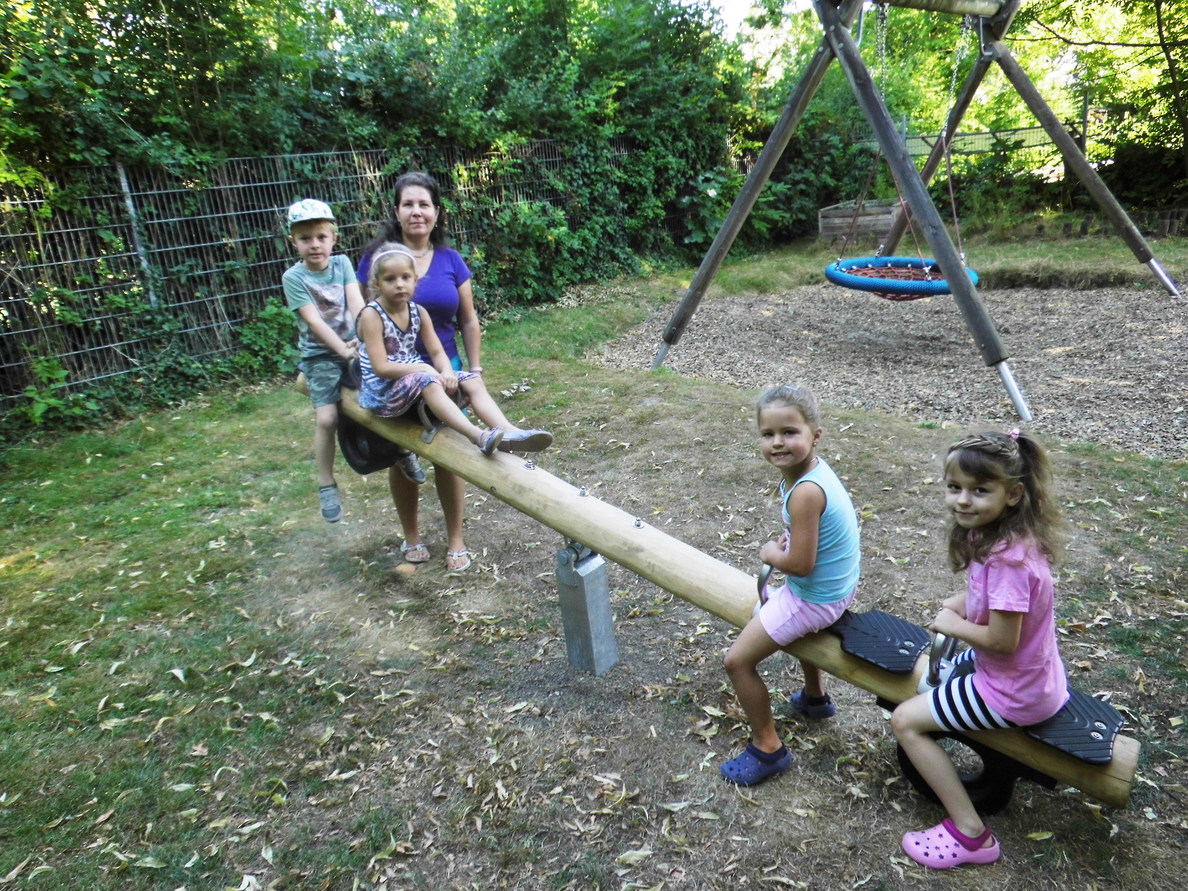 Die Kinder der katholischen Kindertagesstätte (Kita) Vom Göttlichen Wort und Kita-Leitung Kathrin Vollmer freuen sich sehr über die neue Wippe auf dem Außengelände am Wickeder Hellweg 59. Sozusagen ein schönes Abschiedsgeschenk der Kirchengemeinde Vom Göttlichen Wort, die zum 1. August die Kita-Trägerschaft an die Katholische Kindertageseinrichtungen Östliches Ruhrgebiet gGmbH abgetreten hat. "Vielen Dank dafür", sagt Kathrin Vollmer, hier beim Wippen-Test auf dem Kita-Spielplatz.