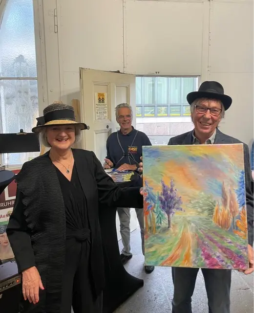 Marlies Rustemeyer vom Auktionsteam der RuhrGallery mit einem glücklichen Spender. Das Werk stammt von der Mülheimer Künstlerin Gisela Lentz. Im Hintergrund freut sich Peter Brill vom Team "ASB-Wünschewagen" über einen 4-stelligen Betrag zur Erfüllung eines letzten Wunsches Schwerstkranker. | Foto: Mülheimer Künstlerbund MKB